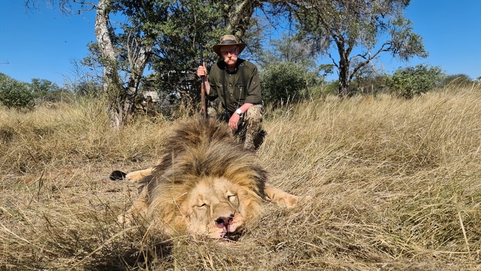 Hunter with his lion trophy after the hunt