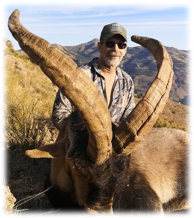 Hunter with his Southeastern ibex trophy on the top of a mountain