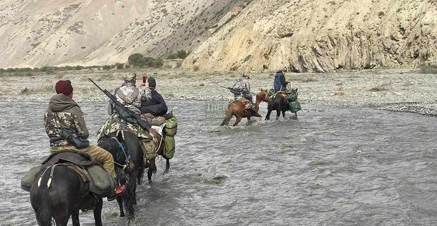 Hunter and guides riding horses