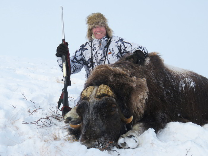 Hunter with his muskox hunting trophy in Greenland