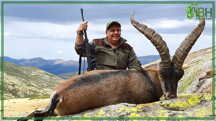 Hunter with his Gredos ibex on Spanish mountains