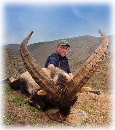 Hunter with his Southeastern ibex trophy on the top of a mountain